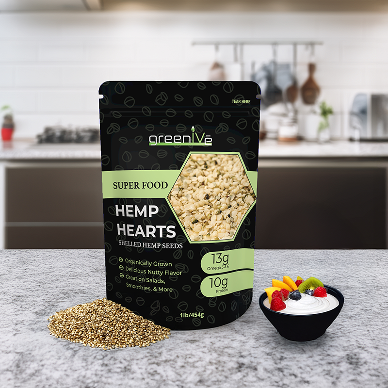 Packaging of greenLife Hemp Hearts on a kitchen counter with seeds and a bowl of fruit.